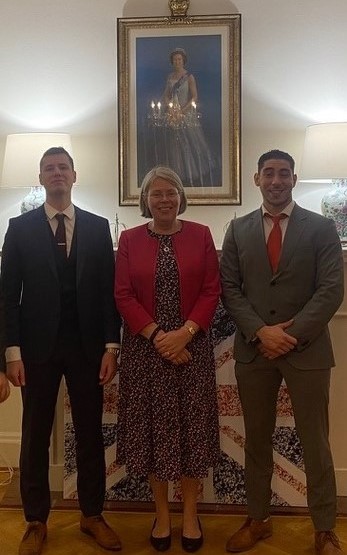 Kolme ihmistä seisoo Yhdistyneen kuningaskunnan suurlähetystössä